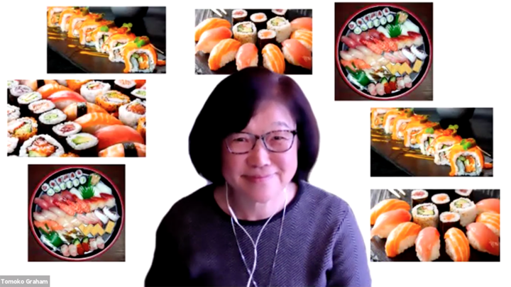 Tomoko Graham, wearing a periwinkle sweater, smiles in front of a Zoom background of collaged sushi photos